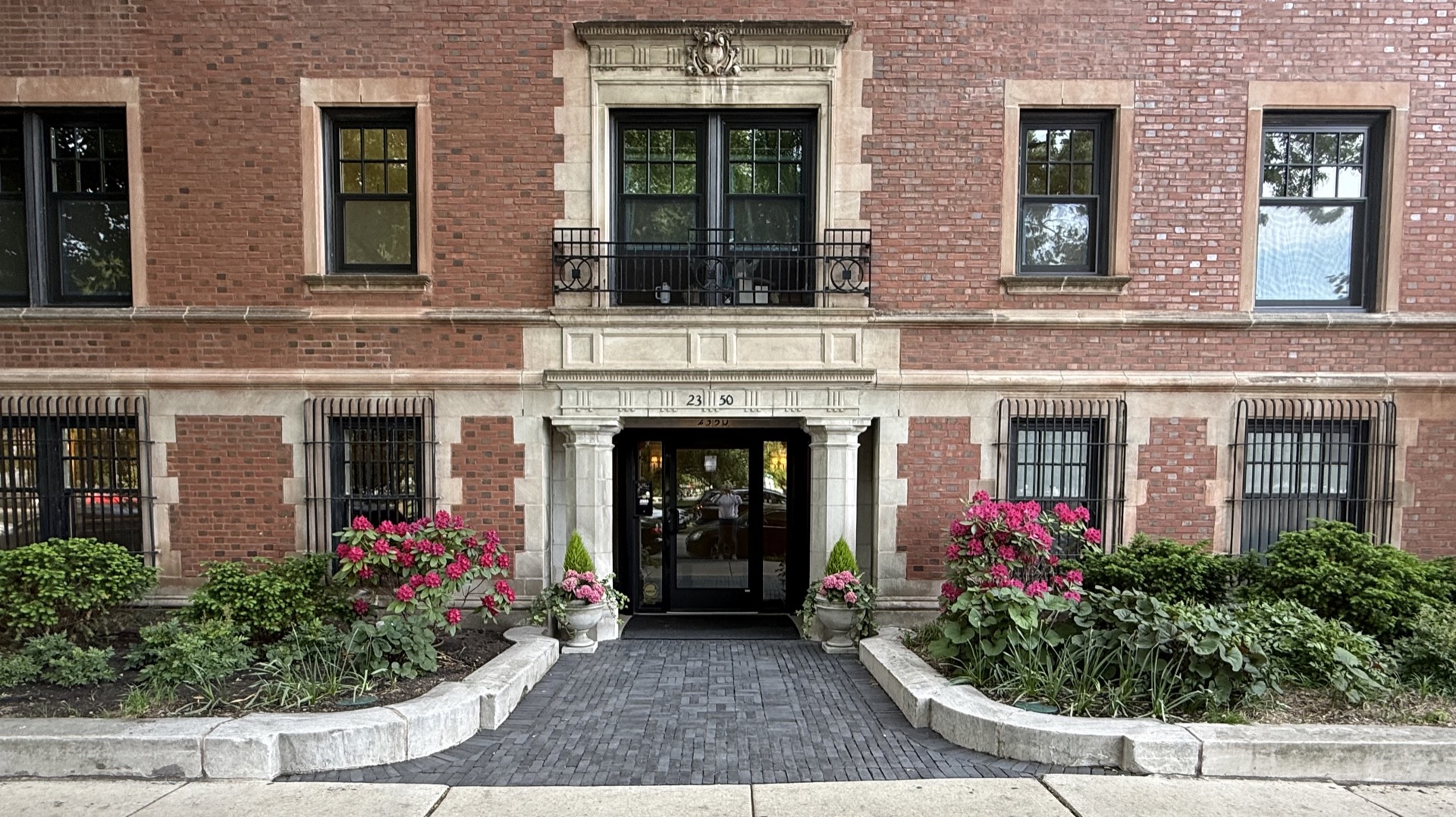 Historic Chicago building entrance framed by garden plantings